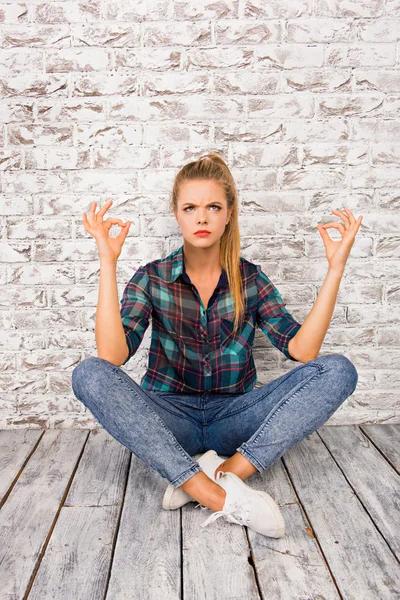 Concentrato meditando ragazza sicura seduta sul pavimento — Foto Stock