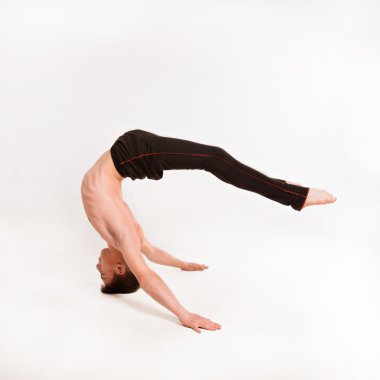 slender man doing gymnastic exercises. Gymnast standing on hands clipart