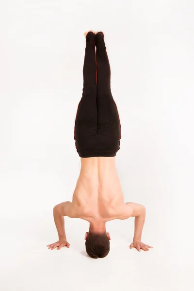 Slender man doing gymnastic exercises. Gymnast standing on hands — Stock Photo, Image