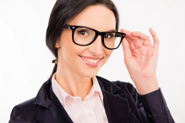 Slimme mooie vrouw in glazen glimlachend en aanpassen van haar glas — Stockfoto