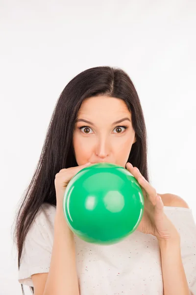 Funny girl inflating a green balloon — Stock Photo, Image