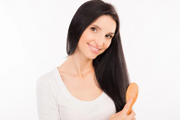 Gelukkig leuke jonge vrouw haar lange haren kammen — Stockfoto