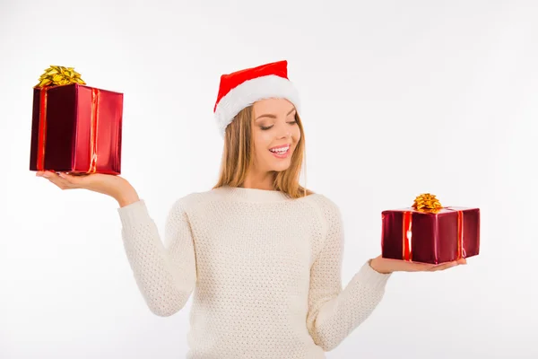 Zadowolony ładny dziewczyna w santa hat wybierz prezenty świąteczne — Zdjęcie stockowe