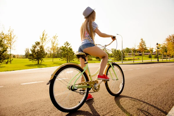 Sexy shapely girl with hat and mini shorts ride a bicycle — Stock Photo, Image