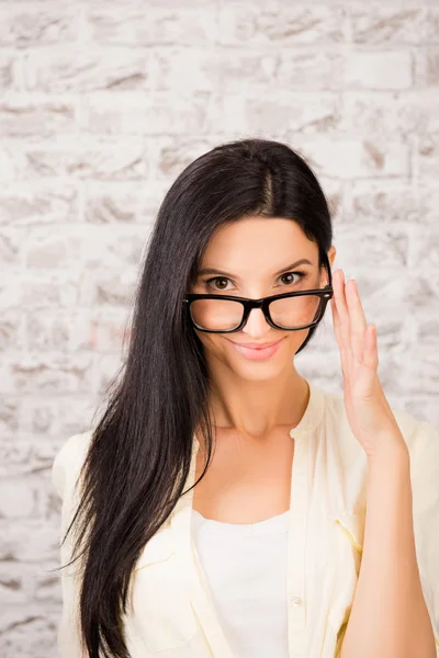 Zeker mooie jonge vrouw die houdt van haar bril — Stockfoto