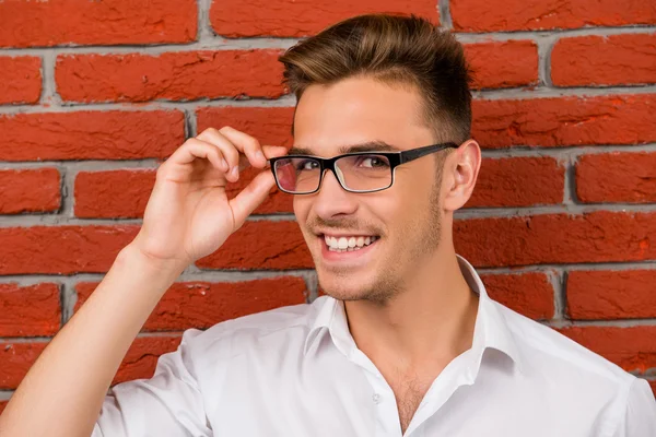 Sutil bonito homem segurando seus óculos — Fotografia de Stock