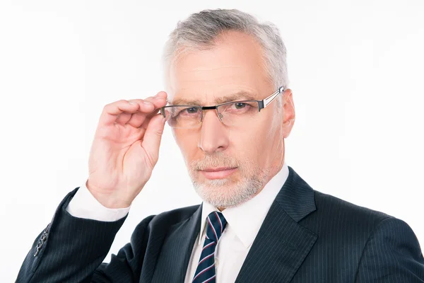 Handsome serios businessman with gray beard holding glasses — Stock Photo, Image
