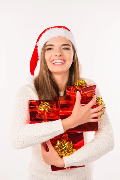 Joyeux jeune femme dans le chapeau de Père Noël avec des cadeaux de Noël — Photo