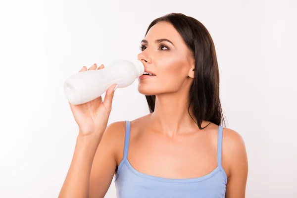 Здорова красива молода жінка п'є йогурт — стокове фото