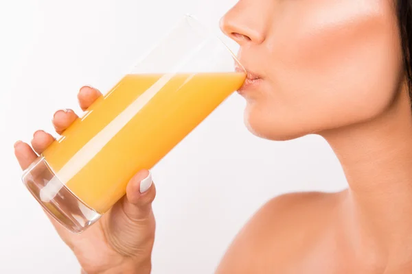 Сексуальная молодая женщина пьет апельсиновый сок — стоковое фото