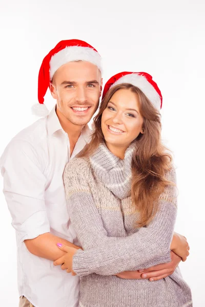 Casal feliz no amor com santa chapéu abraçando uns aos outros — Fotografia de Stock