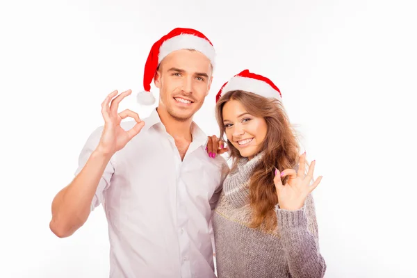 Glad man och kvinna med santa hatt visar gest "ok" — Stockfoto