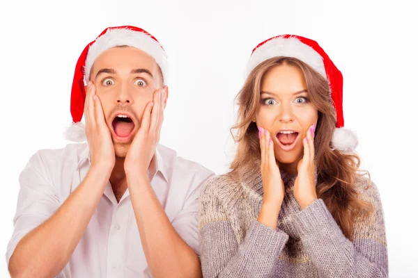 Zaskoczony śmieszne mężczyzna i kobieta z santa hat otworzyć usta — Zdjęcie stockowe
