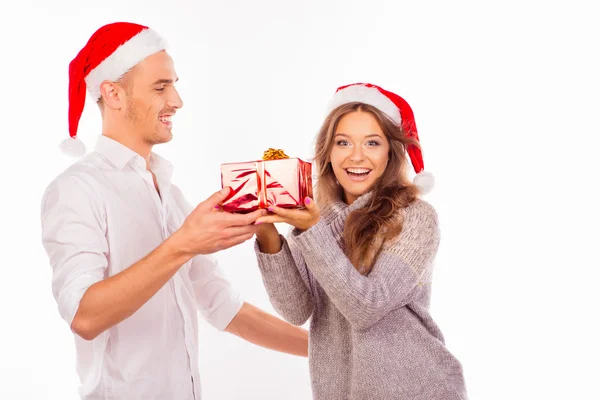 Handsome young man giving a Christmas present to his surprised g — Stock Photo, Image