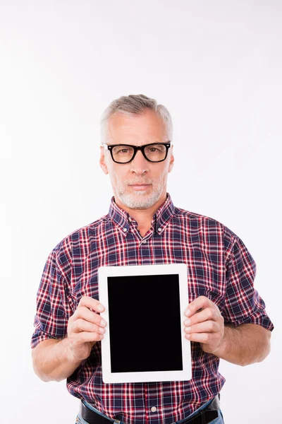 Confident gray aged man with glasses showing a screen of tablet — Stock Photo, Image