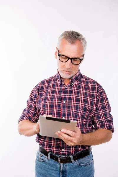 Confident gray aged man with glasses working with tablet — Stock Photo, Image