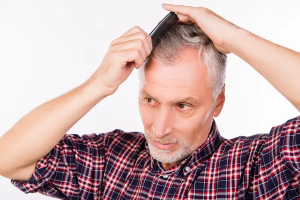 Handsome gray aged man combing hair — Stock Photo, Image