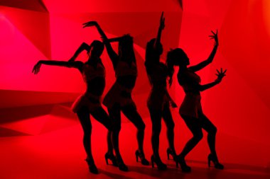 Silhouettes of four slim dancing girls clipart