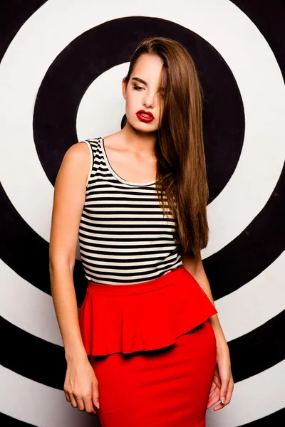 Glamorous girl in a red skirt-basque against the background of c — Stock Photo, Image