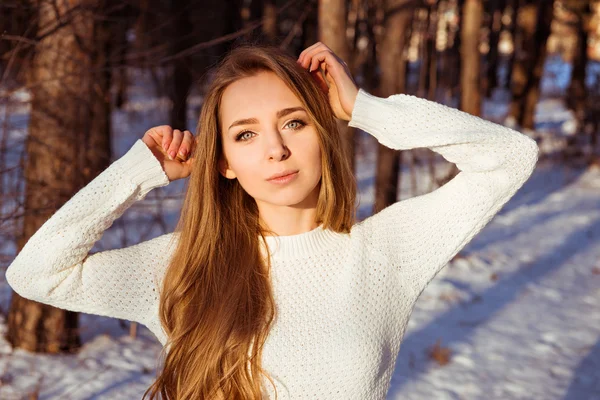 Schönes Mädchen mit weißem Pullover im Winterwald — Stockfoto