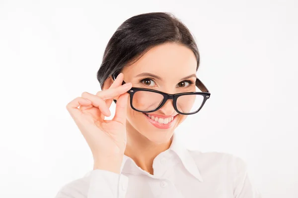 Элегантная деловая женщина регулирует свои очки и улыбается — стоковое фото