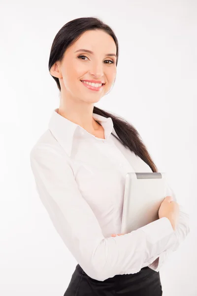 Feliz elegante mujer de negocios sosteniendo la tableta y sonriendo —  Fotos de Stock