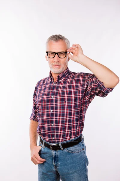 Gray aged man in checkered shirt holding glasses — Stock Photo, Image