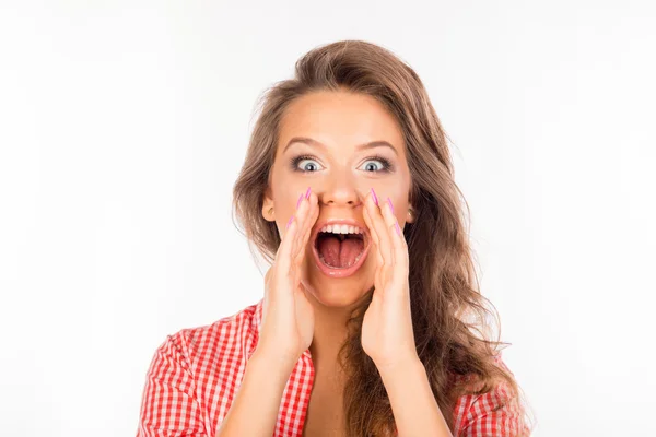 Cheerful young woman in shirt holding hands near mouth shouting — Stock Photo, Image