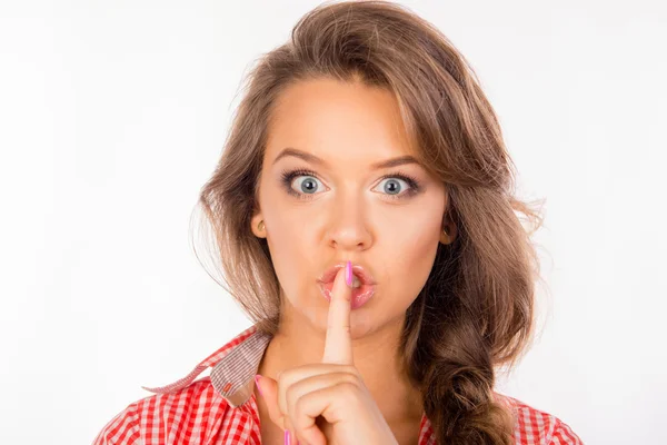 Chica divertida en camisa sosteniendo el dedo en los labios —  Fotos de Stock