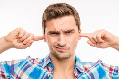 Young man covering his ears ignoring noise clipart