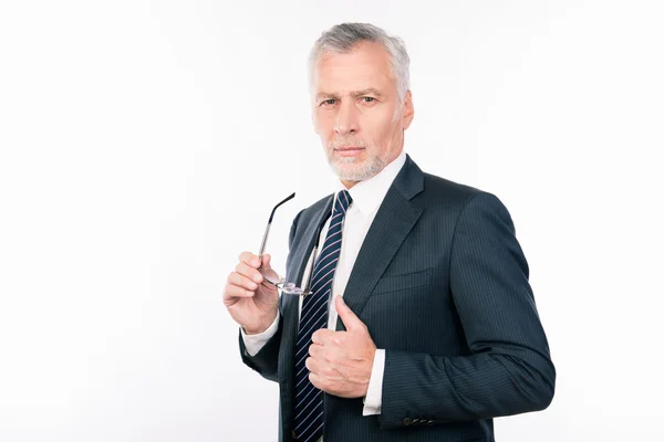 Bonito homem velho em terno de negócios segurando óculos gesticulando thum — Fotografia de Stock