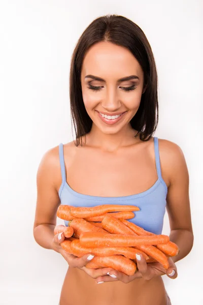 Весела молода жінка тримає моркву — стокове фото