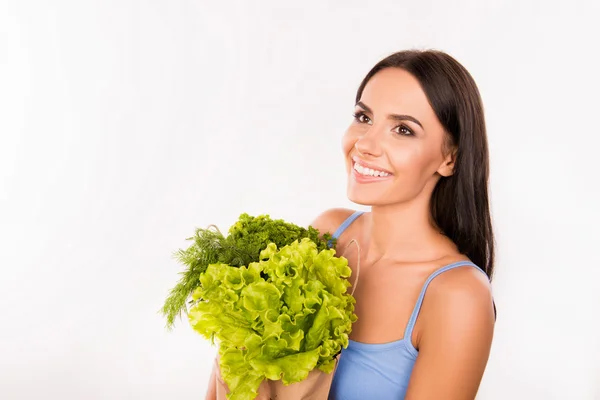 Femme souriante joyeuse avec un paquet plein de légumes verts et — Photo