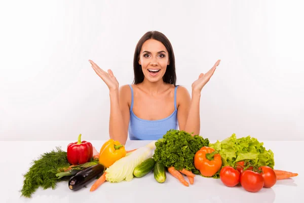 Здивована красива дівчина на дієті з овочами на столі — стокове фото