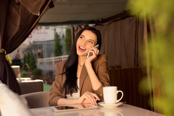 Cute young business woman in a cafe talking on the phone — Stock Photo, Image