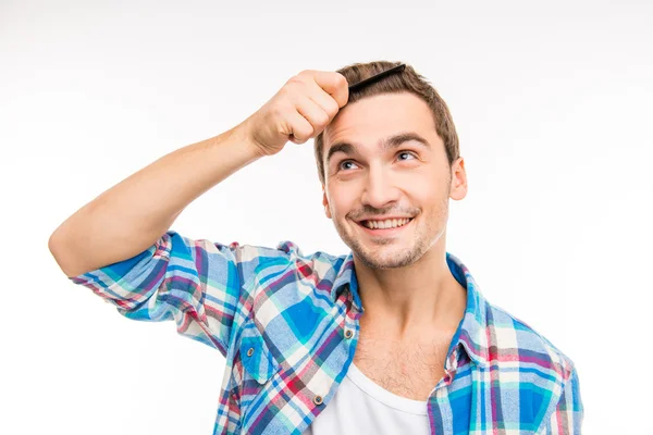 Bonito jovem feliz penteando seu cabelo — Fotografia de Stock