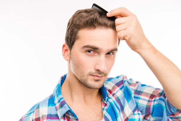 Yakışıklı genç adam onun saç tarama — Stok fotoğraf