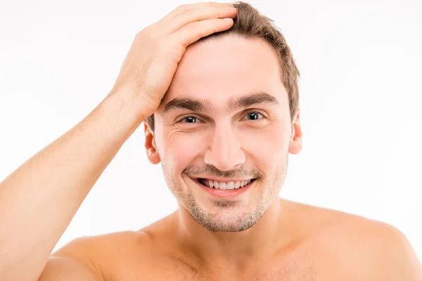 Schöner lustiger junger Mann, der seine Haare berührt — Stockfoto