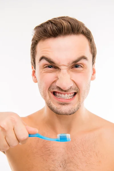 Funny young man holding toothbrush — Stock Photo, Image