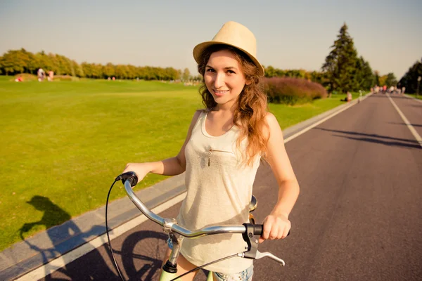 Happy cute girl with hat riding bike — Stock Photo, Image