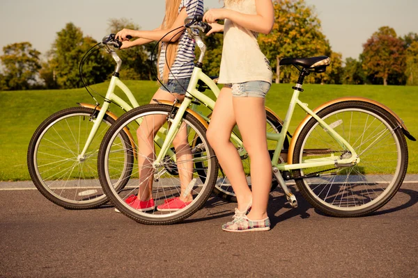 Dos chica bien formada juntos caminando con una bicicleta — Foto de Stock