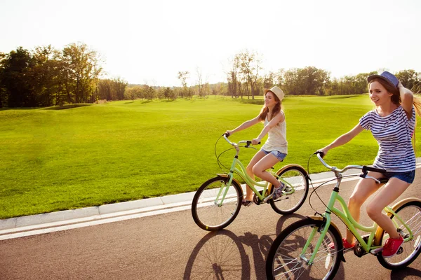 Positieve gelukkig meisjes in liefde fietsen rijden en veel plezier — Stockfoto
