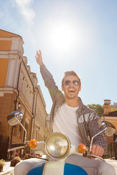 Handsome happy man riding a motorbike picking up one hand — Stock Photo, Image