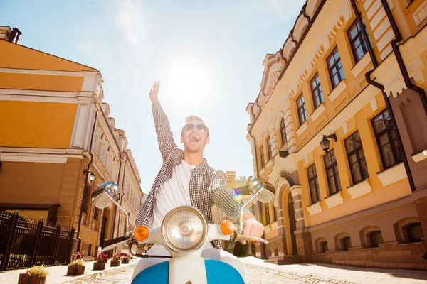Handsome cheerful man riding a motorbike picking up one hand — Stock Photo, Image