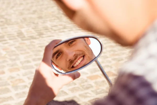 Отражение молодого красивого мужчины в зеркале скутеров — стоковое фото