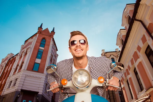 Glücklich schöner junger Mann mit Brille sitzt auf dem Motorrad — Stockfoto