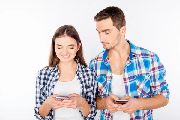 Mujer alegre escribiendo mensaje ignorando a su novio — Foto de Stock