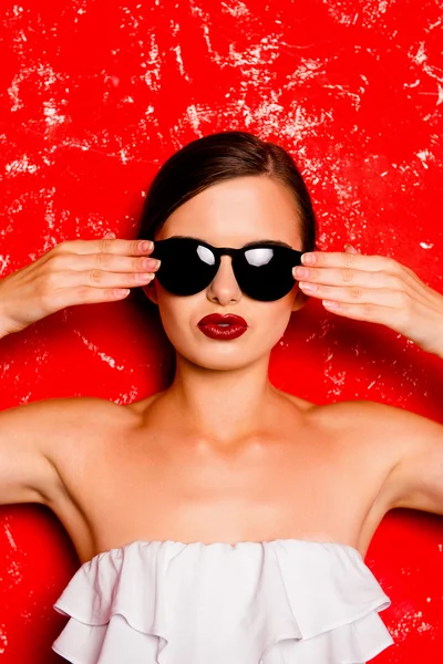 Glamorosa chica alegre con gafas frías contra la ba roja — Foto de Stock