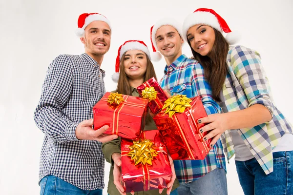Felices amigos en sombreros de santa celebración de regalos de Navidad — Foto de Stock