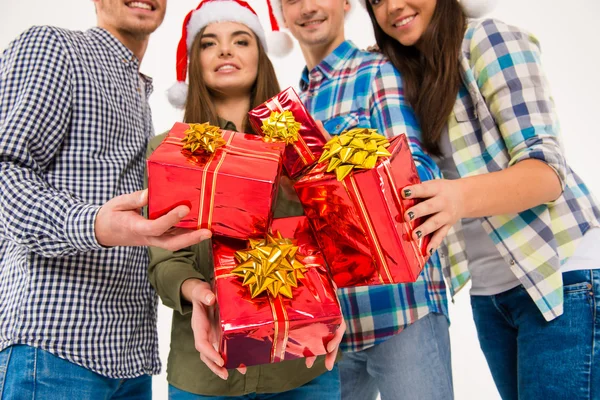 Closeup fotografie šťastné přátel v santa čepice drží Vánoce p — Stock fotografie